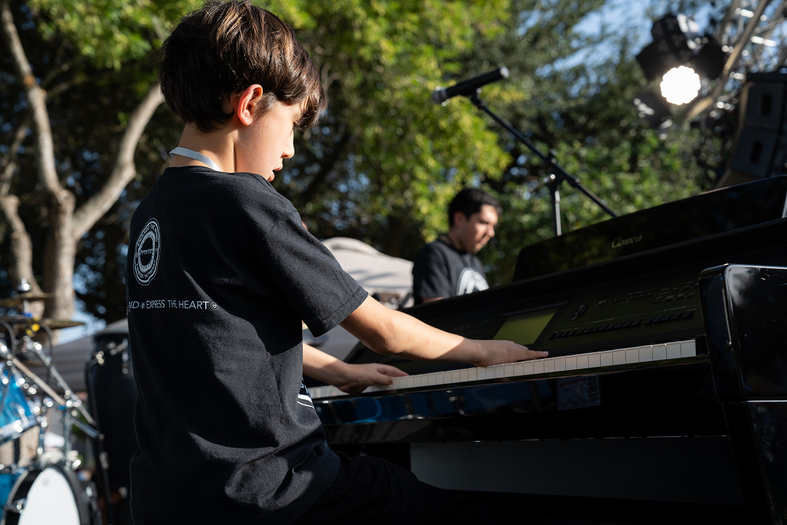 Young pianist performing outdoors at a previous festival